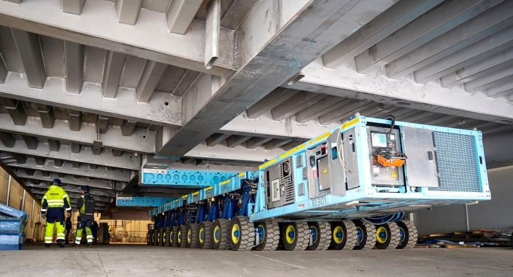 Large duplex stainless steel bridge deck for the Härnön road bridge, fabricated in the workshop, being transported on SPMT units to the sea‑pier assembly area for final assembly operations at Western Shipyard in Klaipėda
