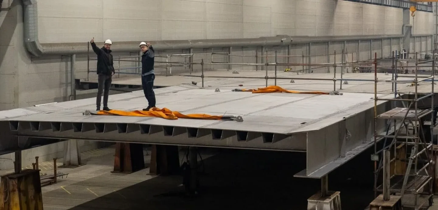 engineers inspecting a massive prefabricated stainless steel bridge