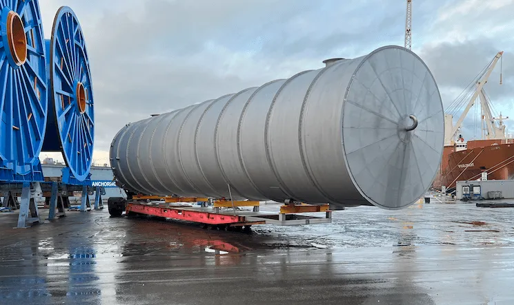  Large stainless steel storage tank being transported on a trailer at a seaport pier in front of the WTS workshop after pickling and passivation treatment
